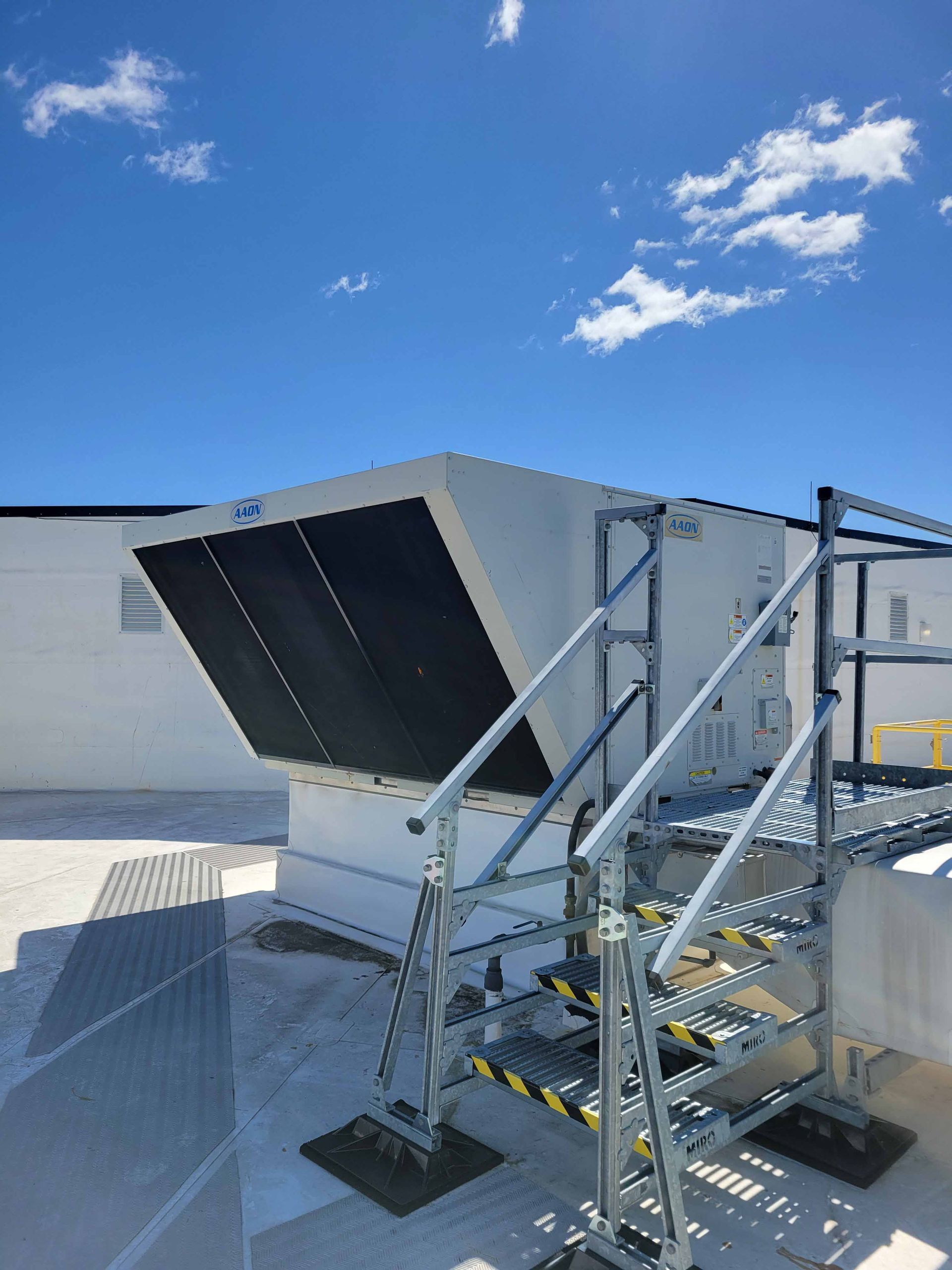 A building with stairs leading up to it and a blue sky in the background.