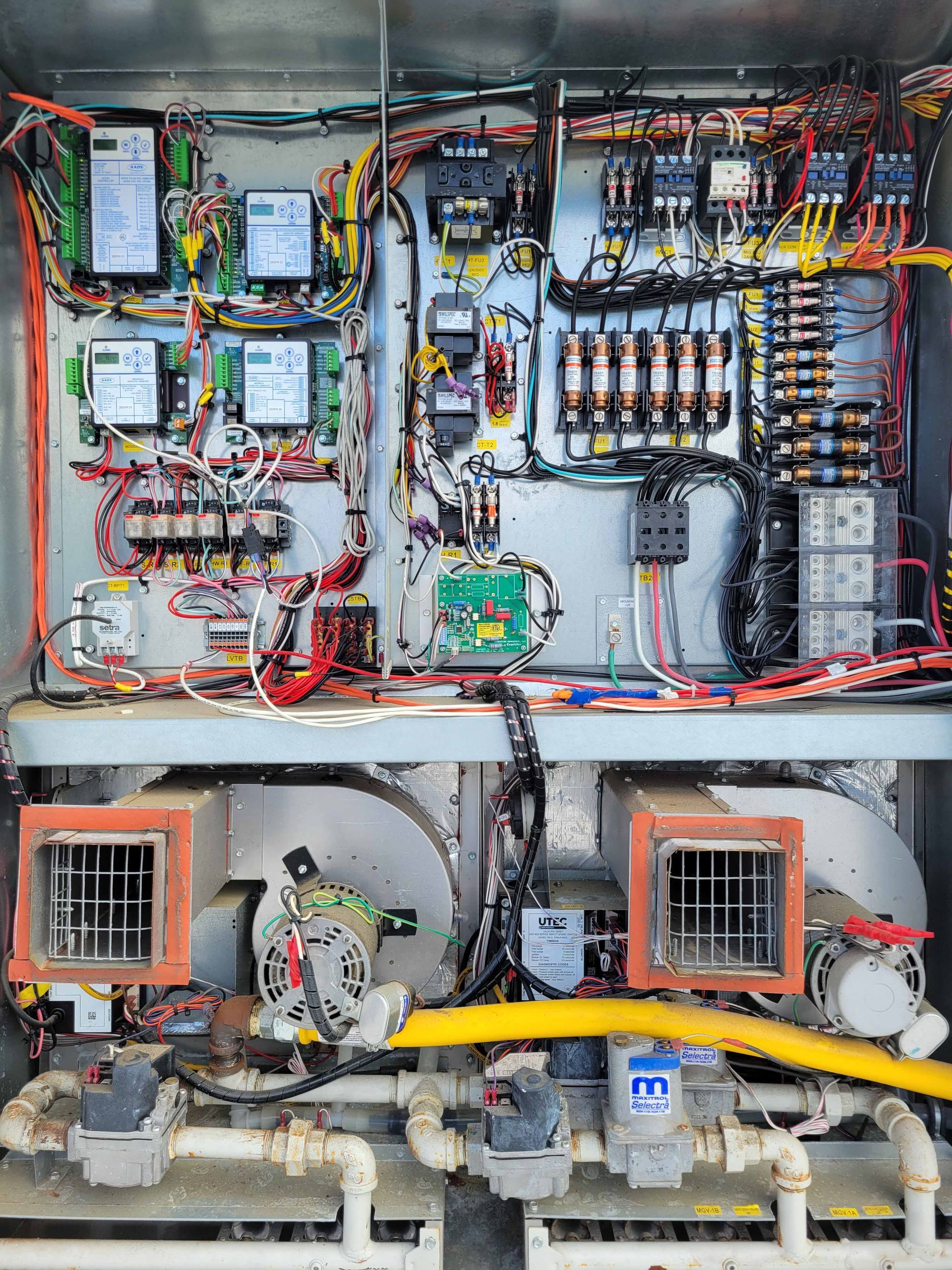 The inside of a electrical box with a lot of wires coming out of it.