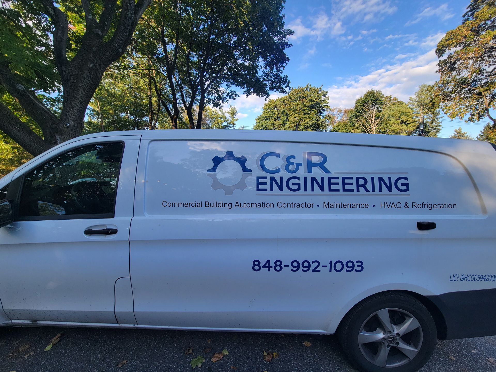 A white van with the words c & r engineering on the side is parked on the side of the road.