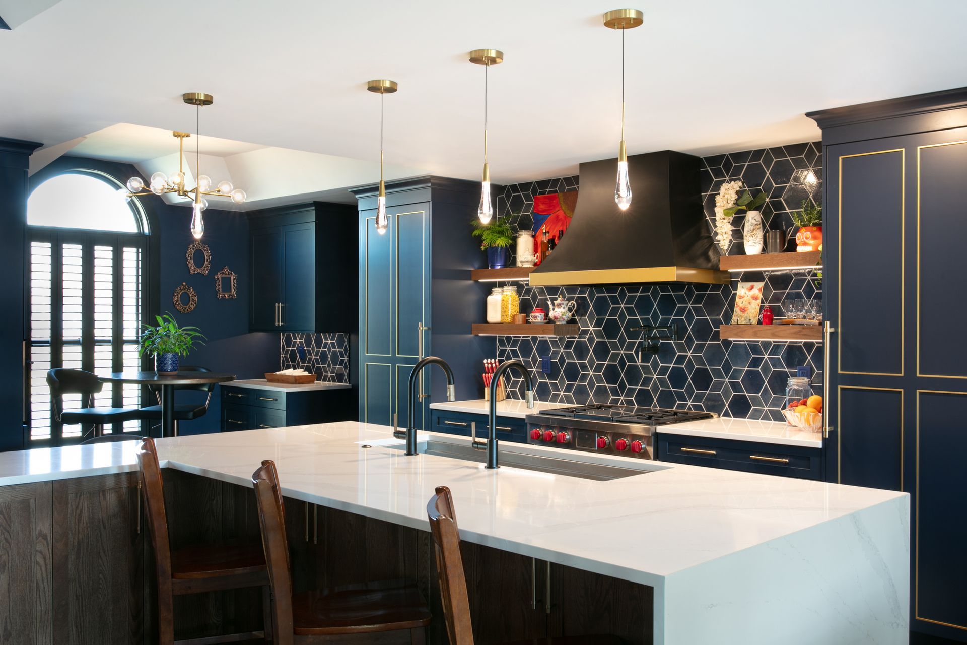 Modern kitchen with navy blue cabinets, white countertops, and gold accents.