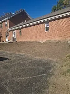 A large brick house with a lot of dirt in front of it.