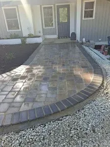 A brick walkway is being built in front of a house.