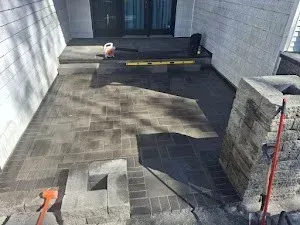 A patio is being built in the backyard of a house.