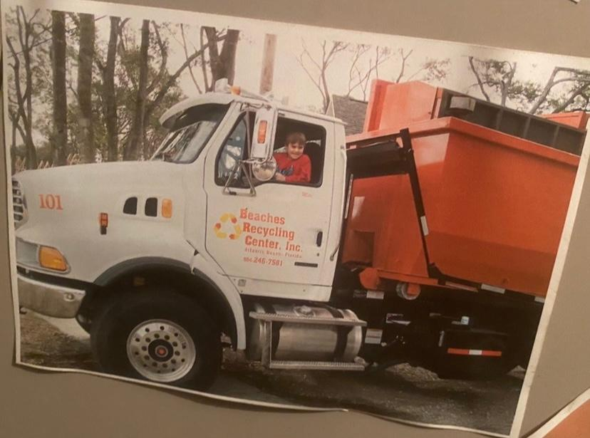 A picture of a dumpster truck with the number 101 on it