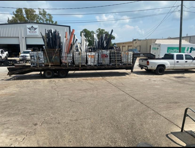 A white truck is pulling a trailer full of supplies
