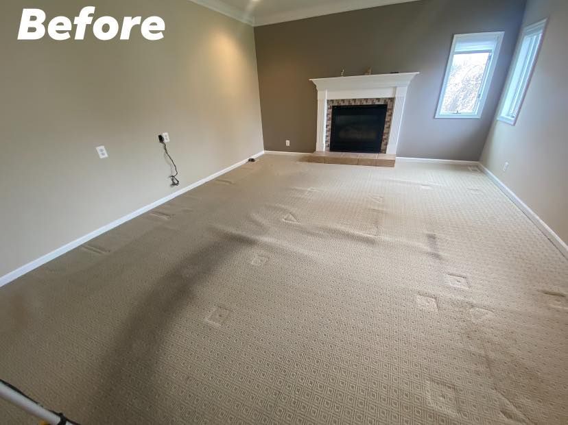 Room with beige carpet and a fireplace, tan walls, and a small window.