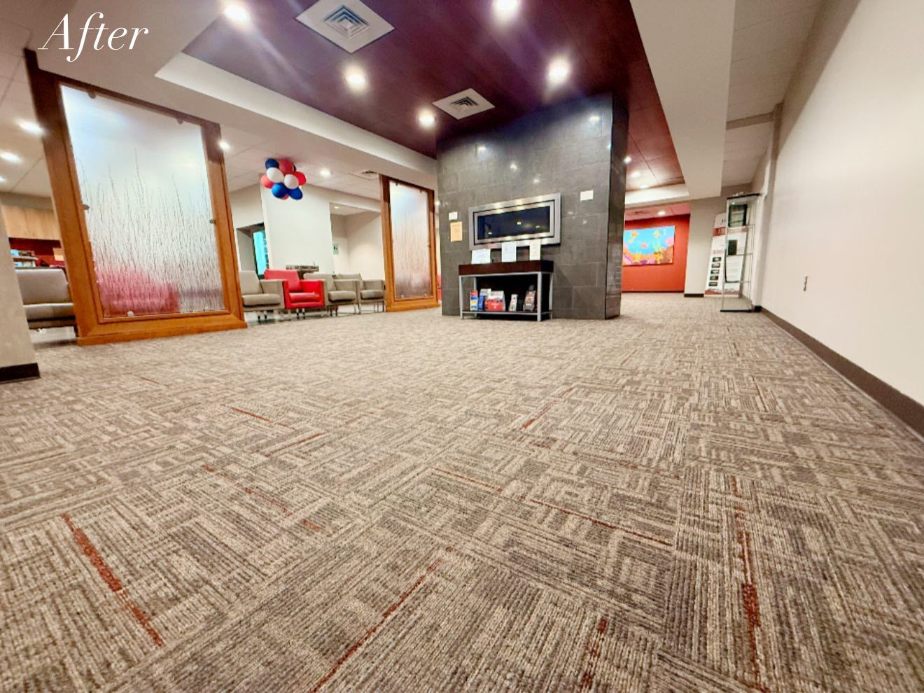 Newly carpeted waiting room with chairs, TV, and decorative glass panels.