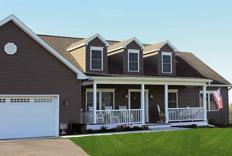 A large brown house with a porch and a garage