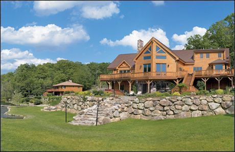 A large house with a stone wall in front of it