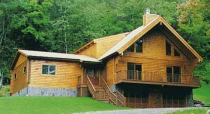 A large wooden house is surrounded by trees and grass.