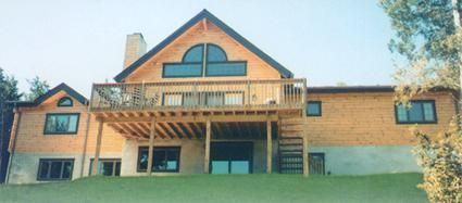 A large house with a large deck on the back of it