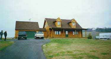 A couple of people are standing in front of a large house.