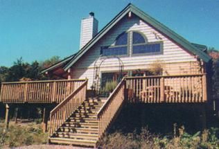 A house with a large deck and stairs leading up to it