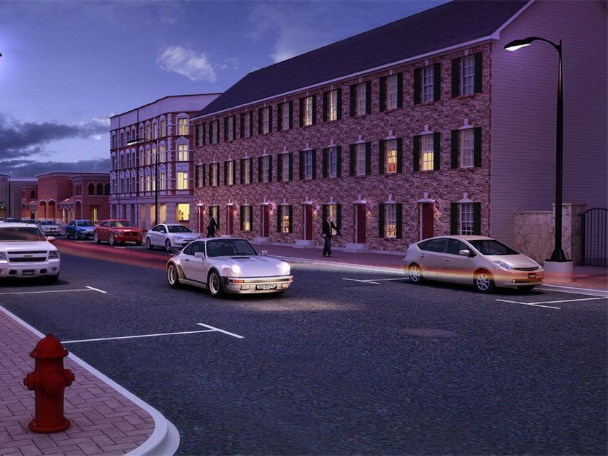 Cars are driving down a street in front of a large building