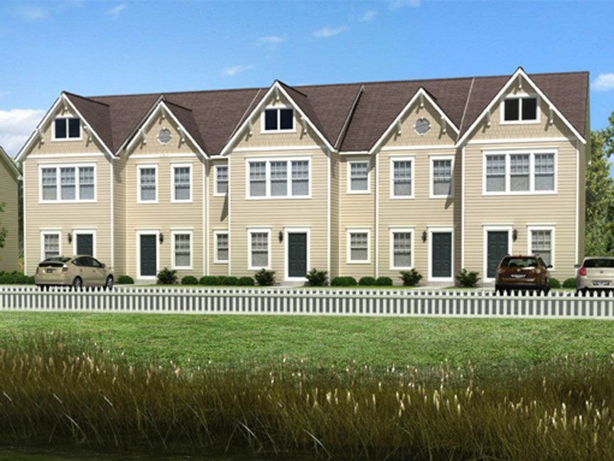 A row of houses with cars parked in front of them