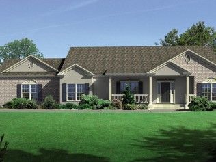 A large brick house with a brown roof is sitting on top of a lush green lawn.