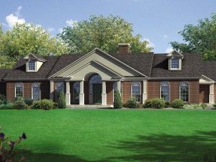 A large brick house with a large lawn in front of it