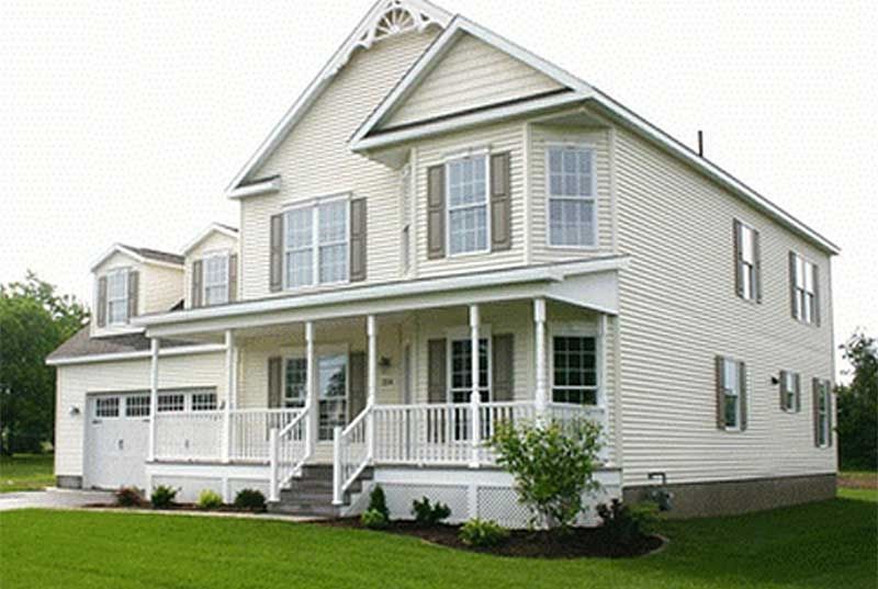 A large white house with a porch and a garage