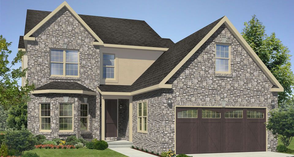 A large stone house with a brown garage door