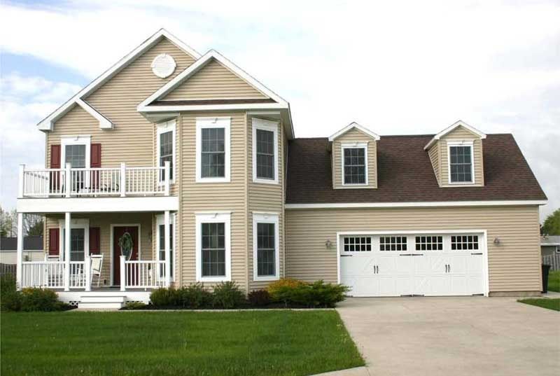A large house with a brown roof and a white garage door