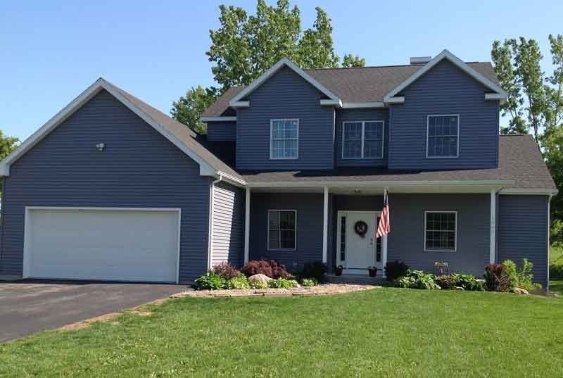 A large blue house with a white garage door