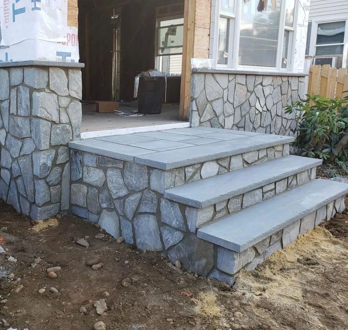 Stone front porch with steps and railing