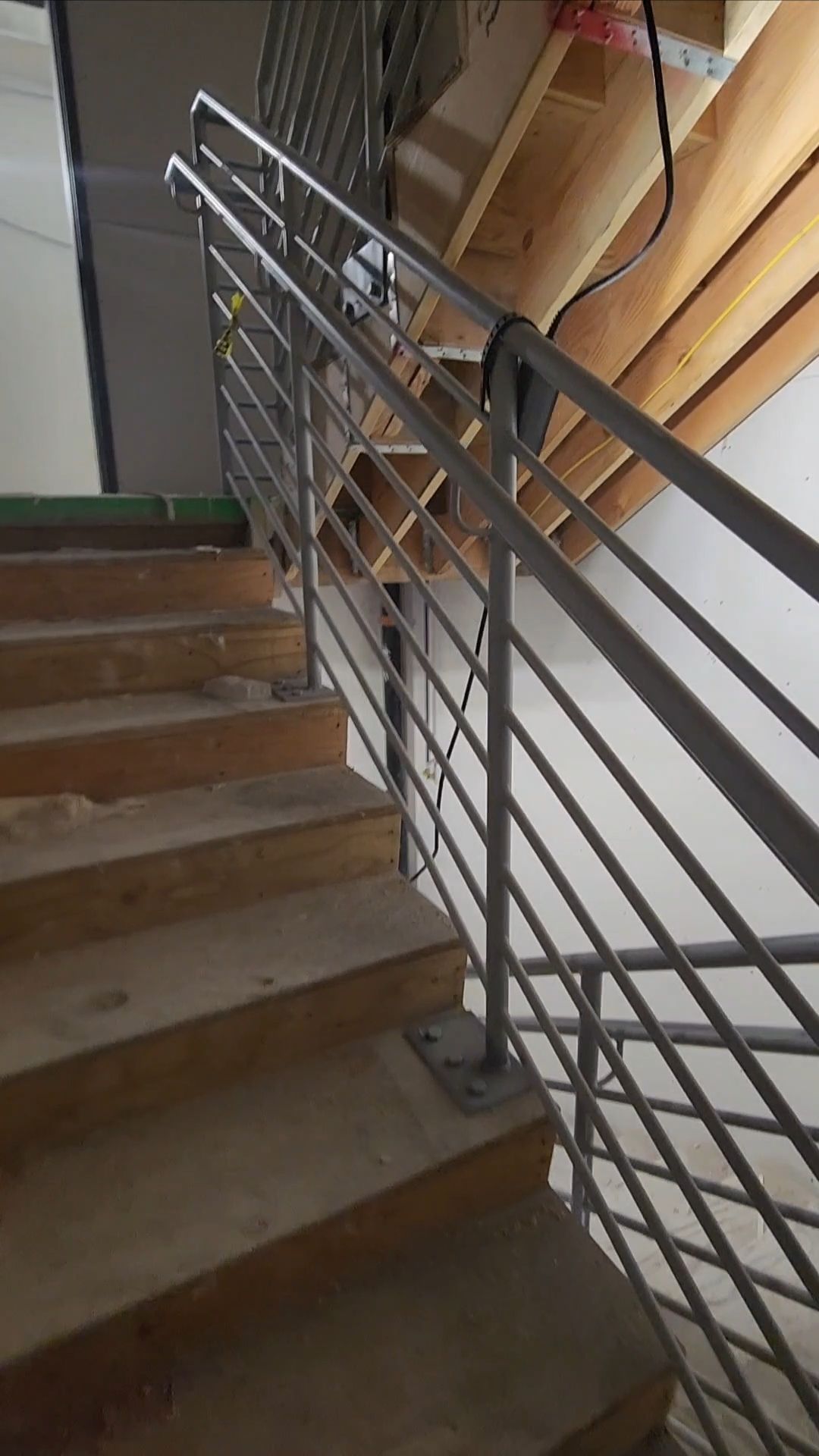 Wooden staircase with metal handrail.