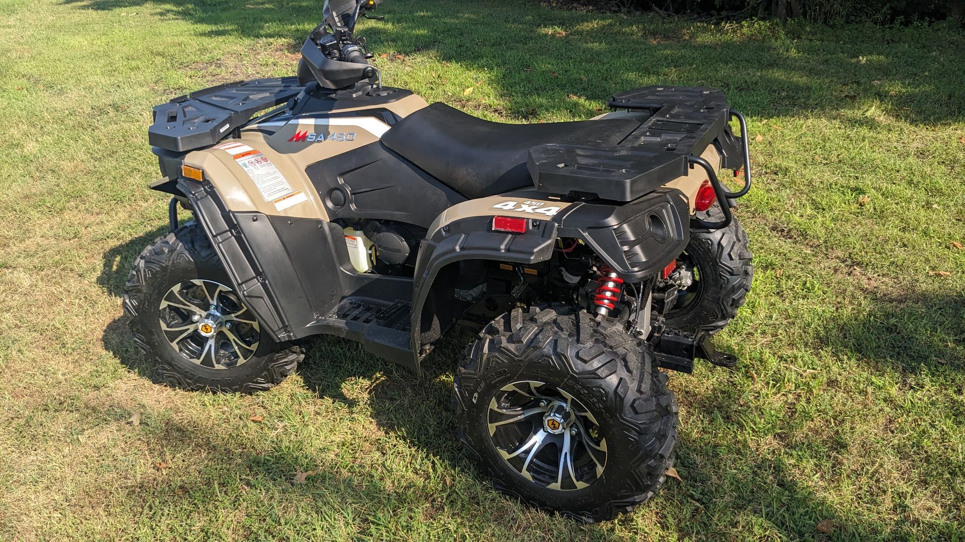 All-terrain vehicle parked on grass, shown in side view.