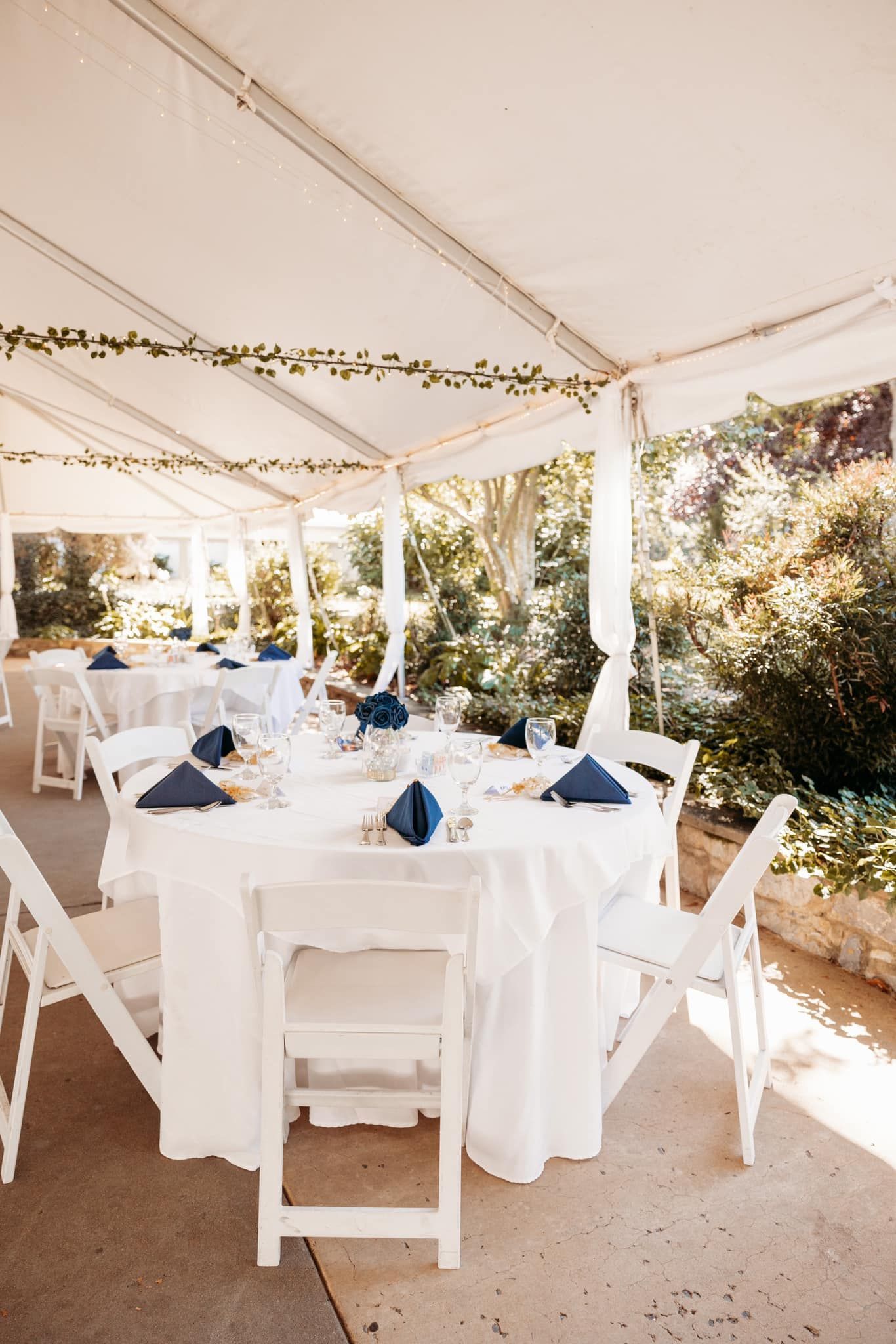 A tent with tables and chairs set up for a wedding reception
