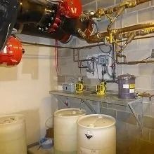 Basement with industrial equipment, tanks, pipes, and pumps. Mostly gray, red, and yellow colors.