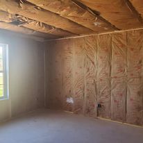 An empty room with insulation on the walls and ceiling.