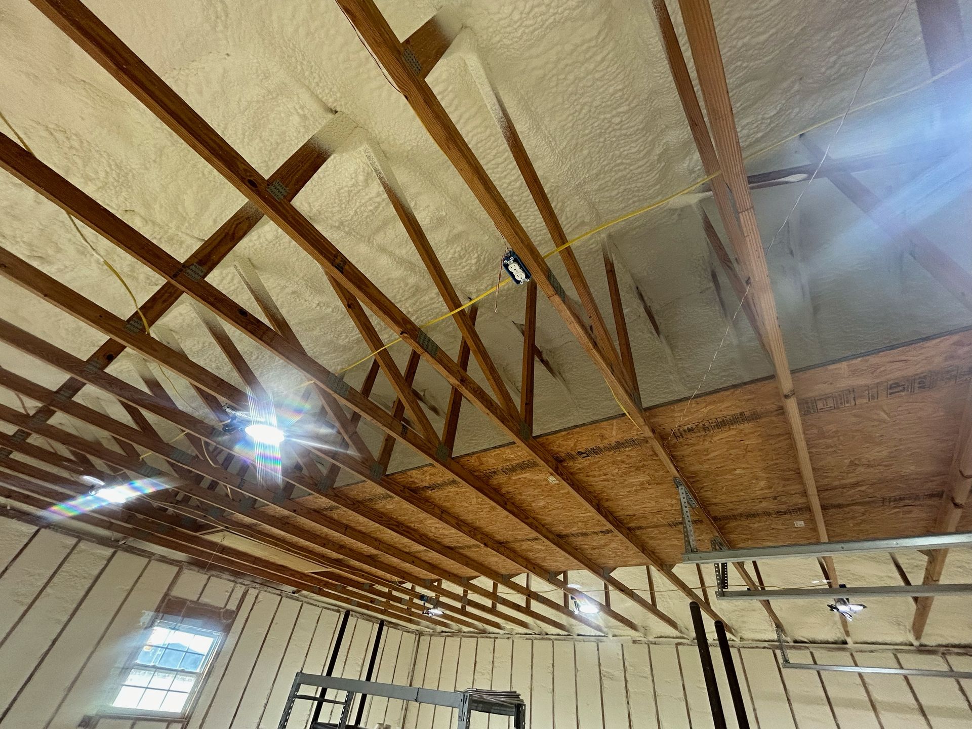 The ceiling of a building is covered in foam and wooden beams.