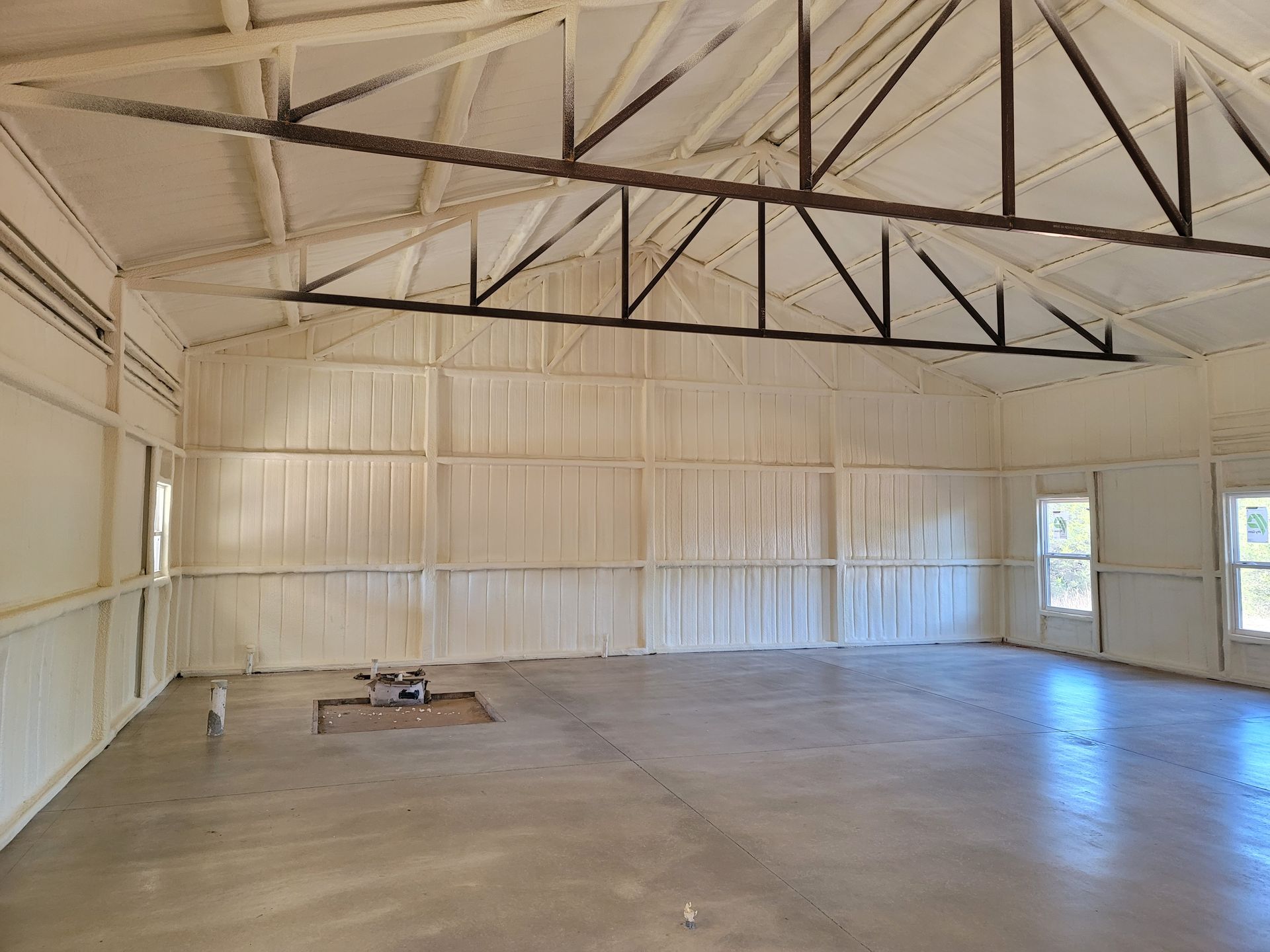 A large empty room with white walls and a concrete floor.