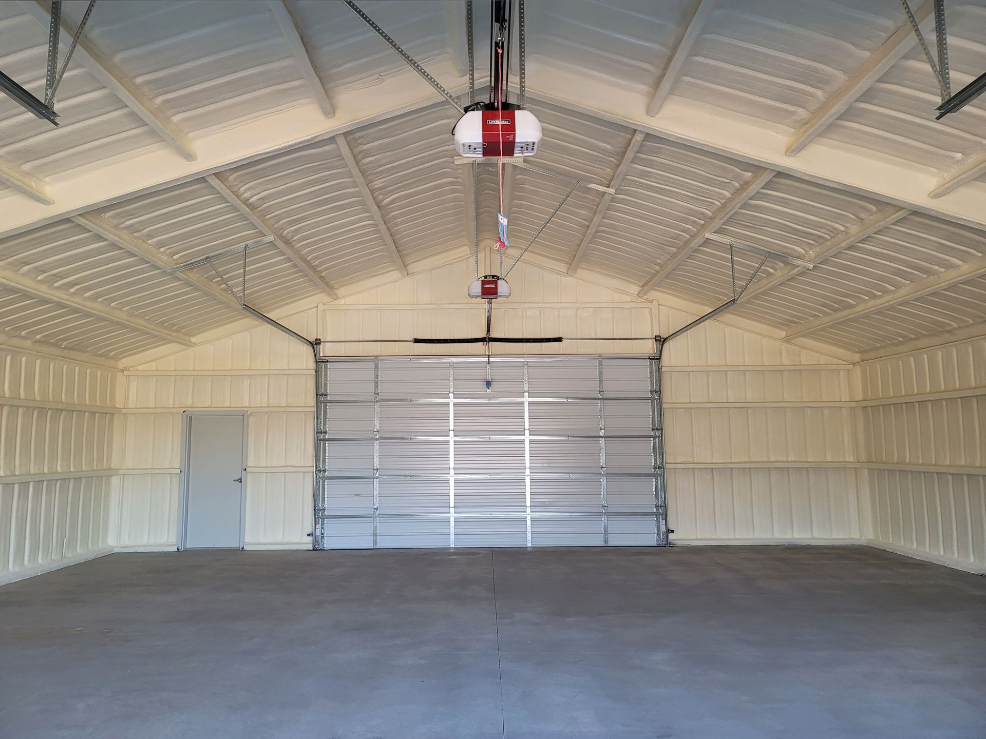 A large empty garage with a garage door open.
