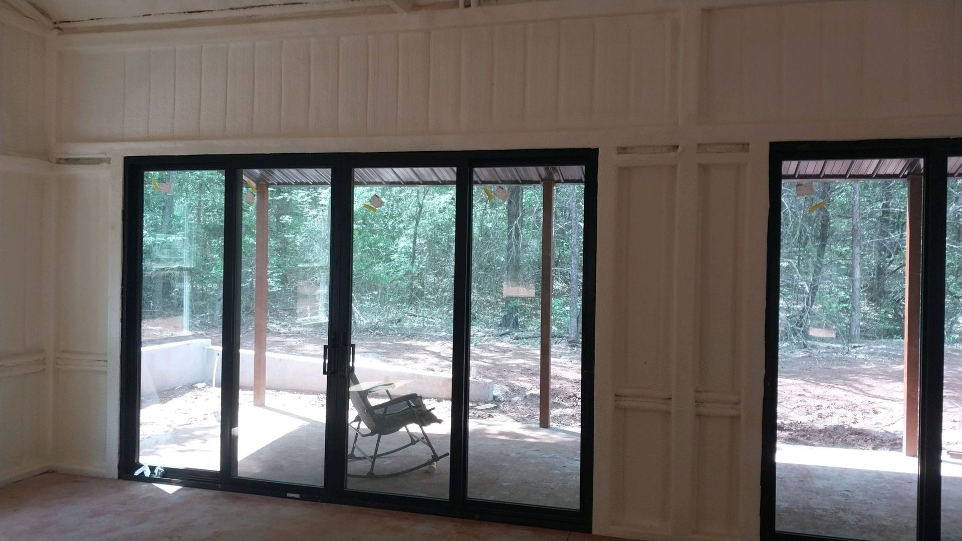 A room with a lot of windows and a rocking chair in it.