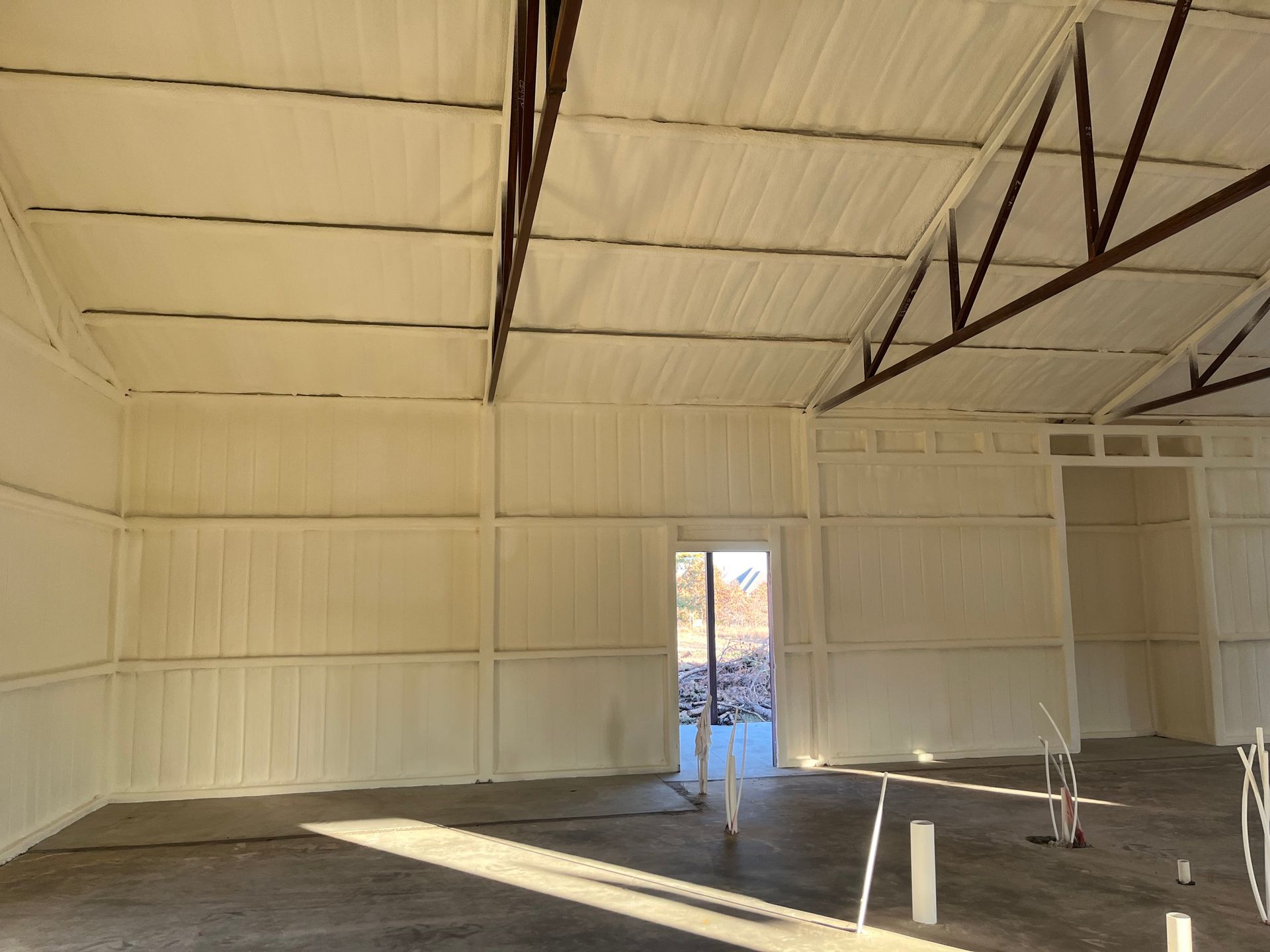 The inside of a building with white walls and a brown roof.