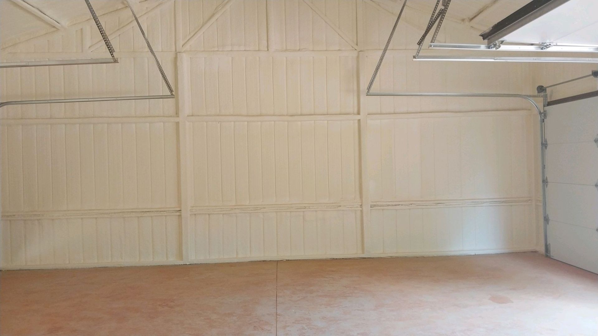 An empty garage with white walls and a garage door.