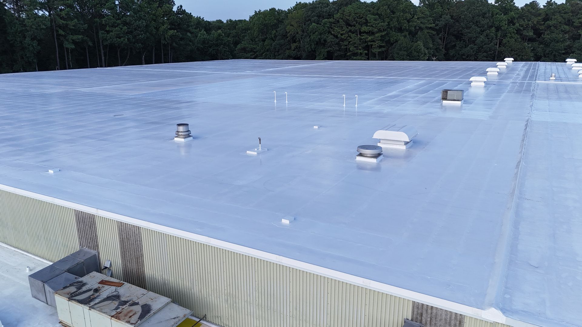 A large white roof with a lot of vents on it.