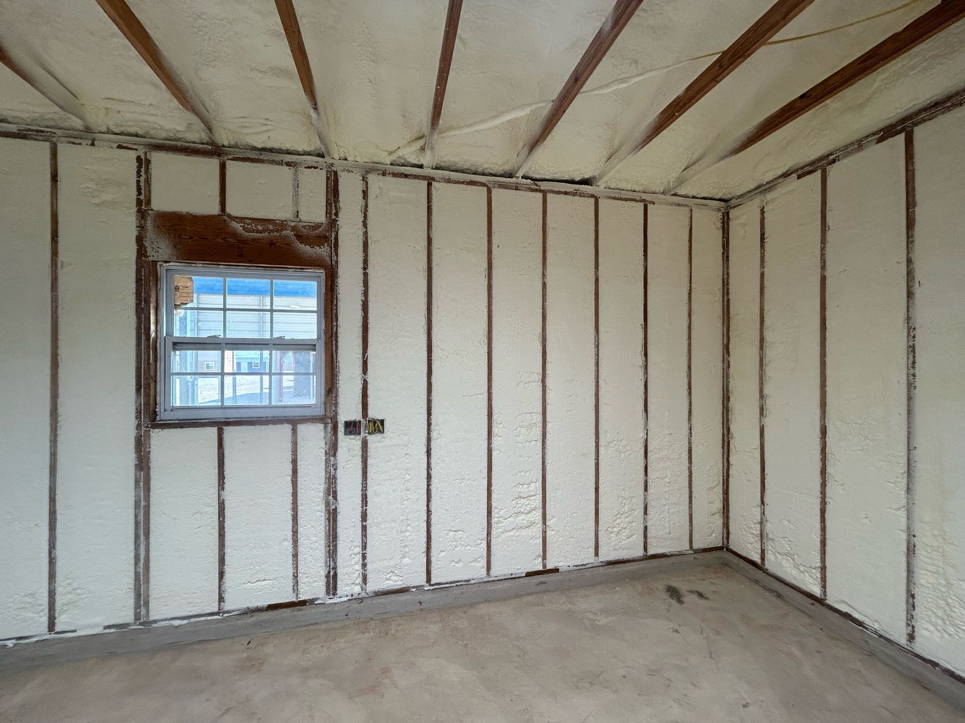 An empty room with foam on the walls and a window