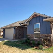 A blue house with a white garage door and a large window.