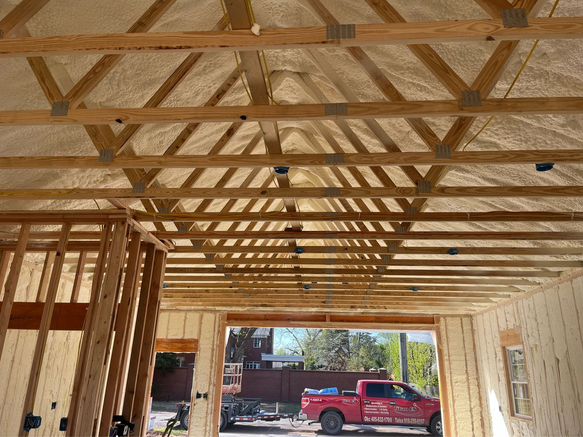 A red truck is parked in a garage under construction.