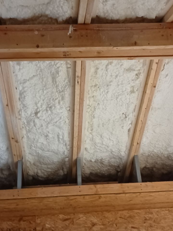 A ceiling with wooden beams and foam on it.
