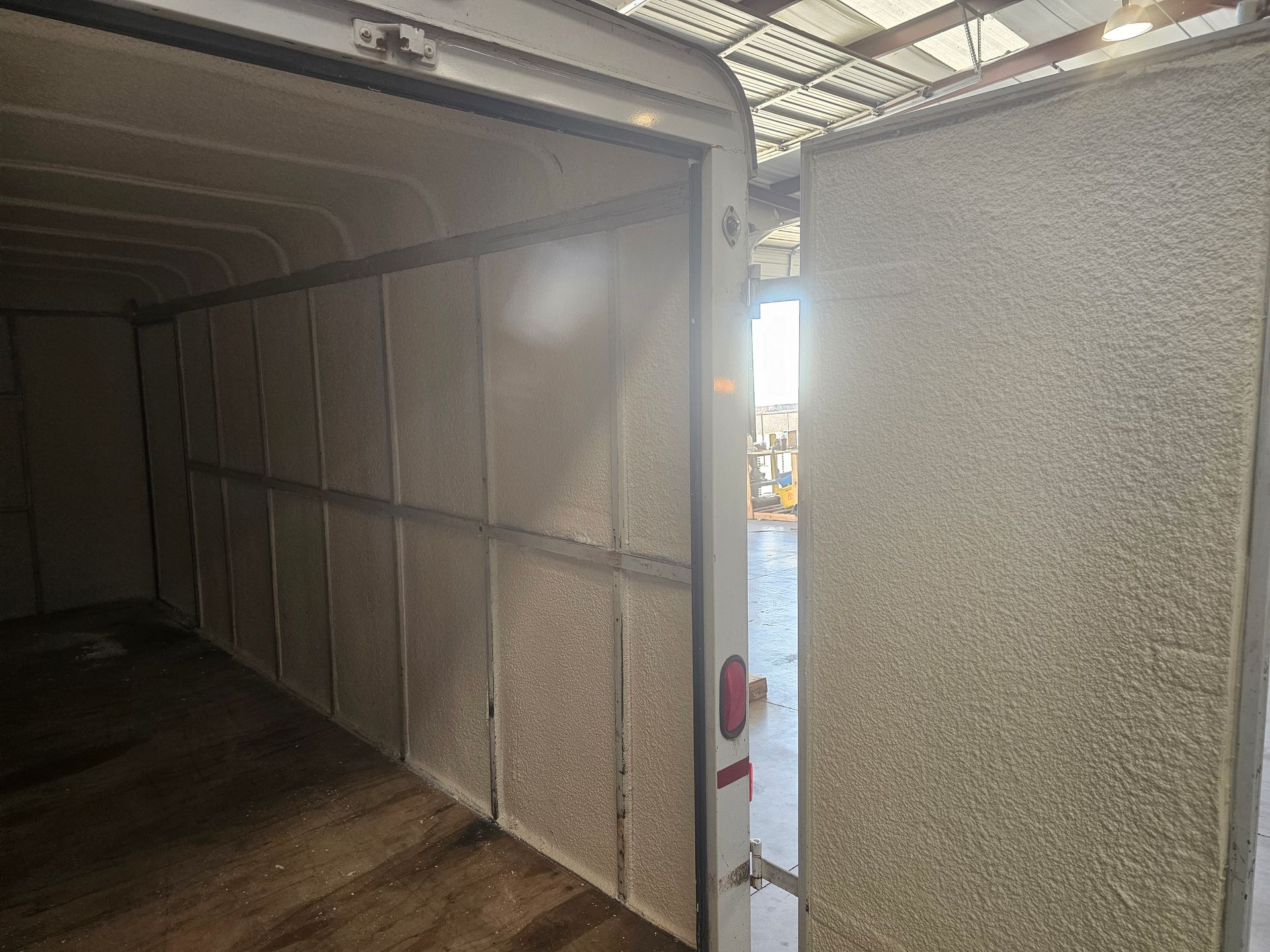 The inside of a trailer with a door open.