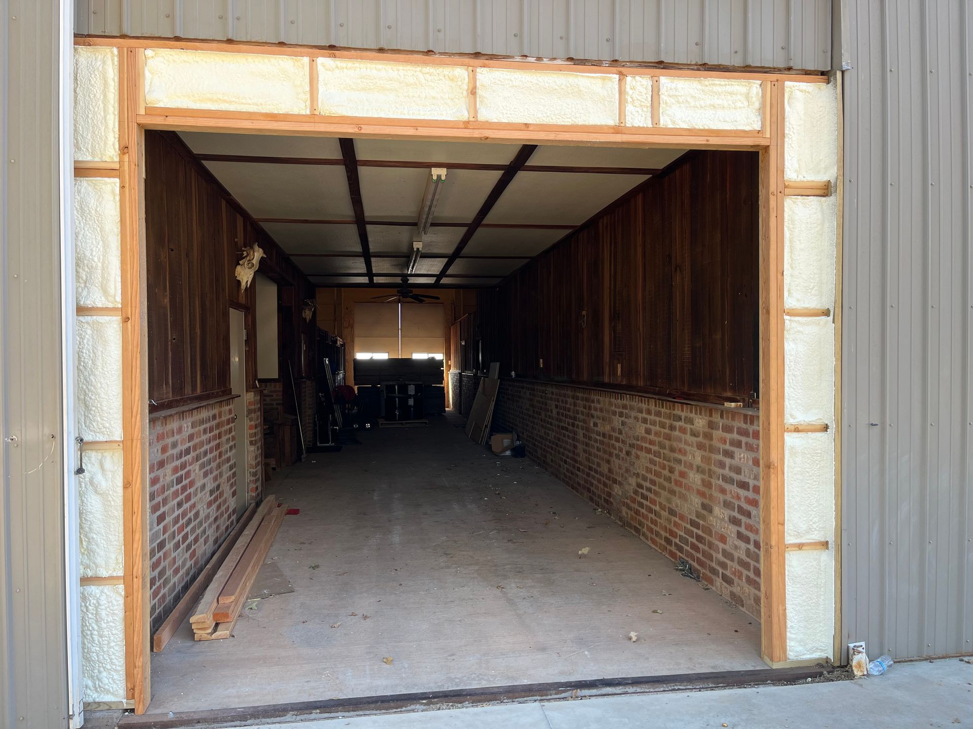 An empty garage with brick walls and a wooden door