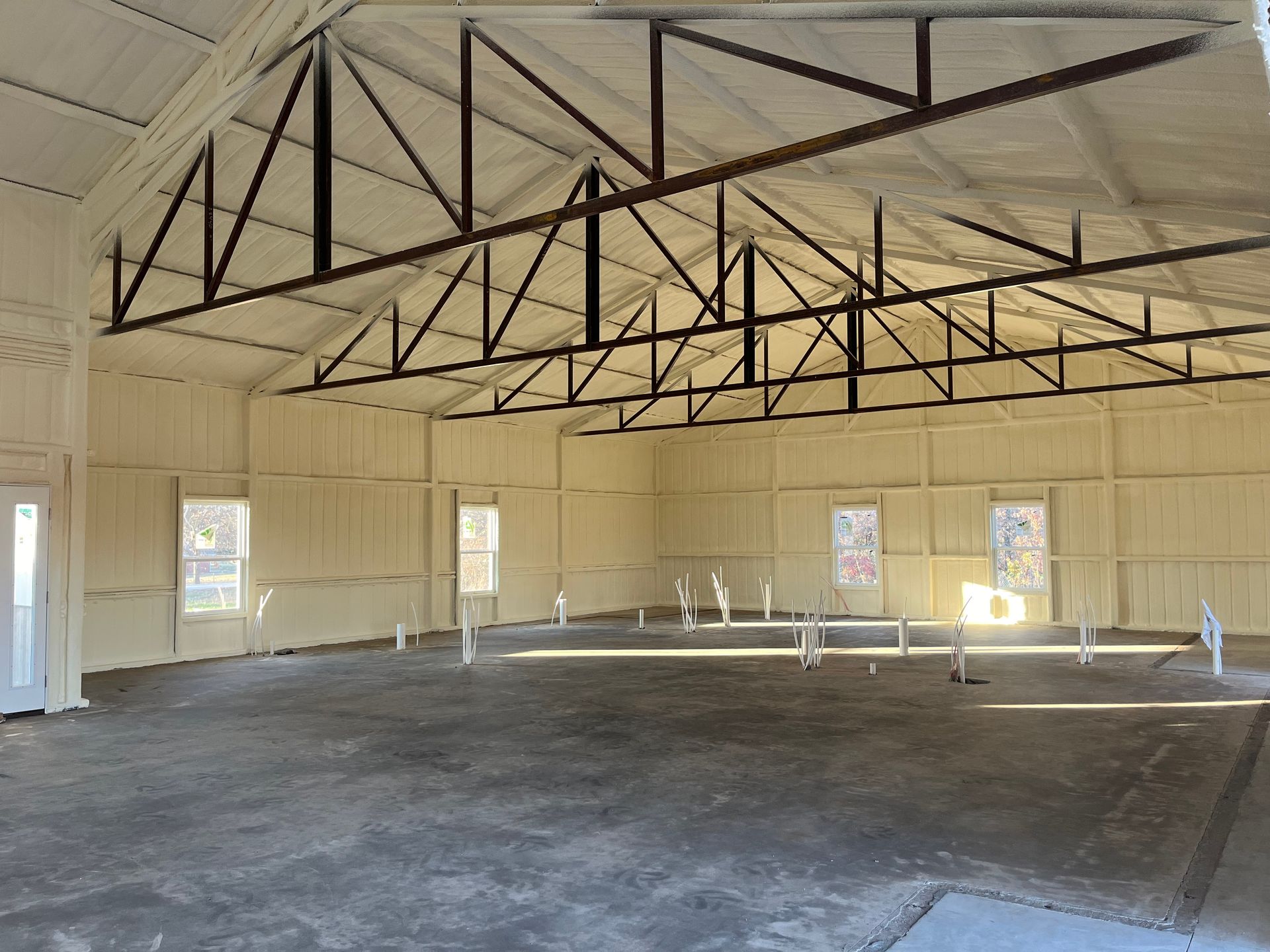 A large empty room with a ceiling and a few windows