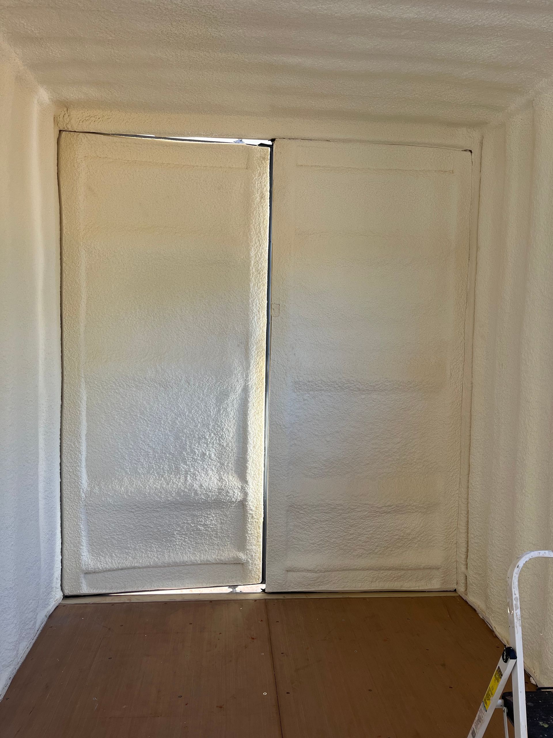 A room with a door and a ladder in it