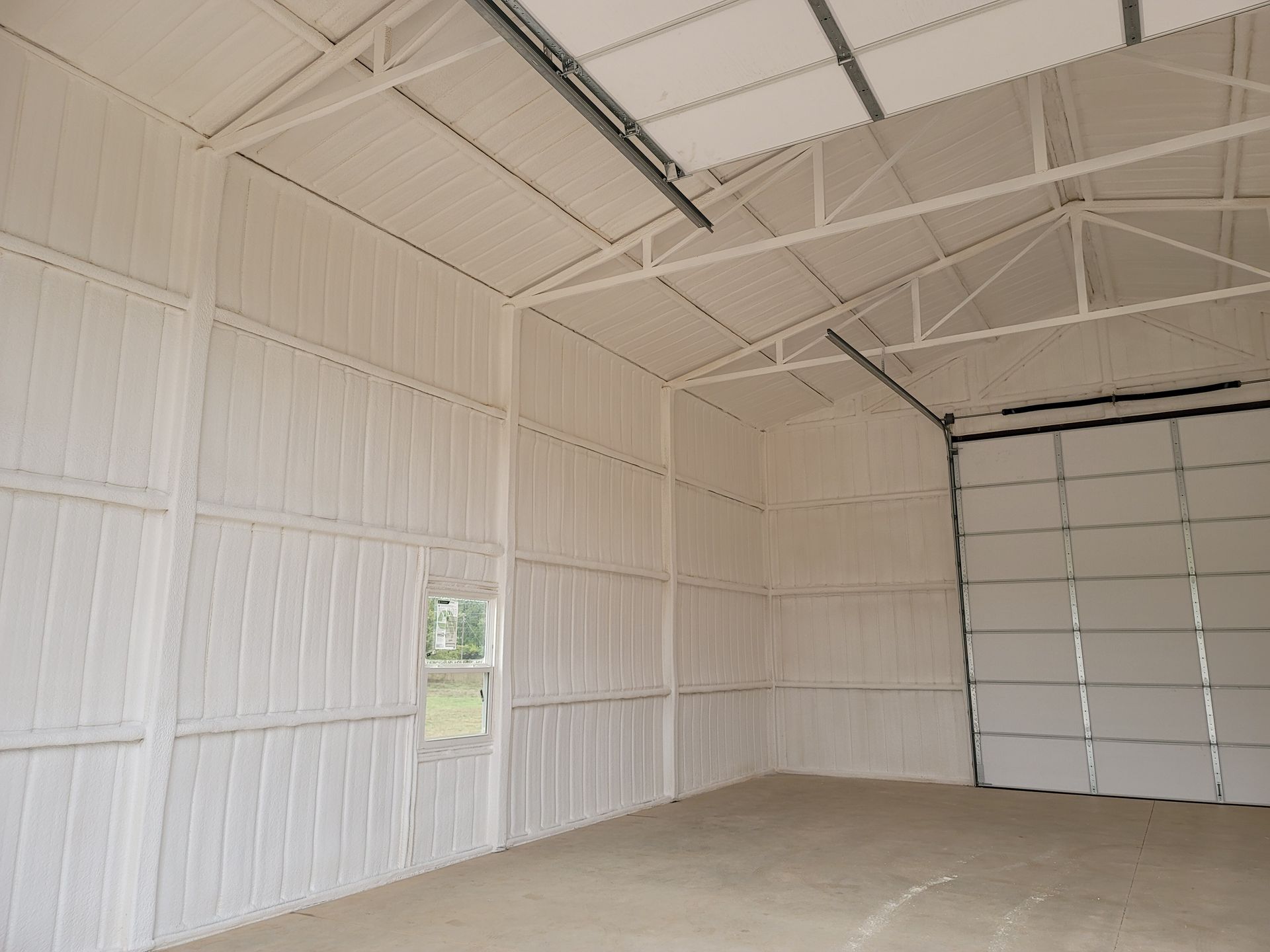 An empty garage with white walls and a garage door