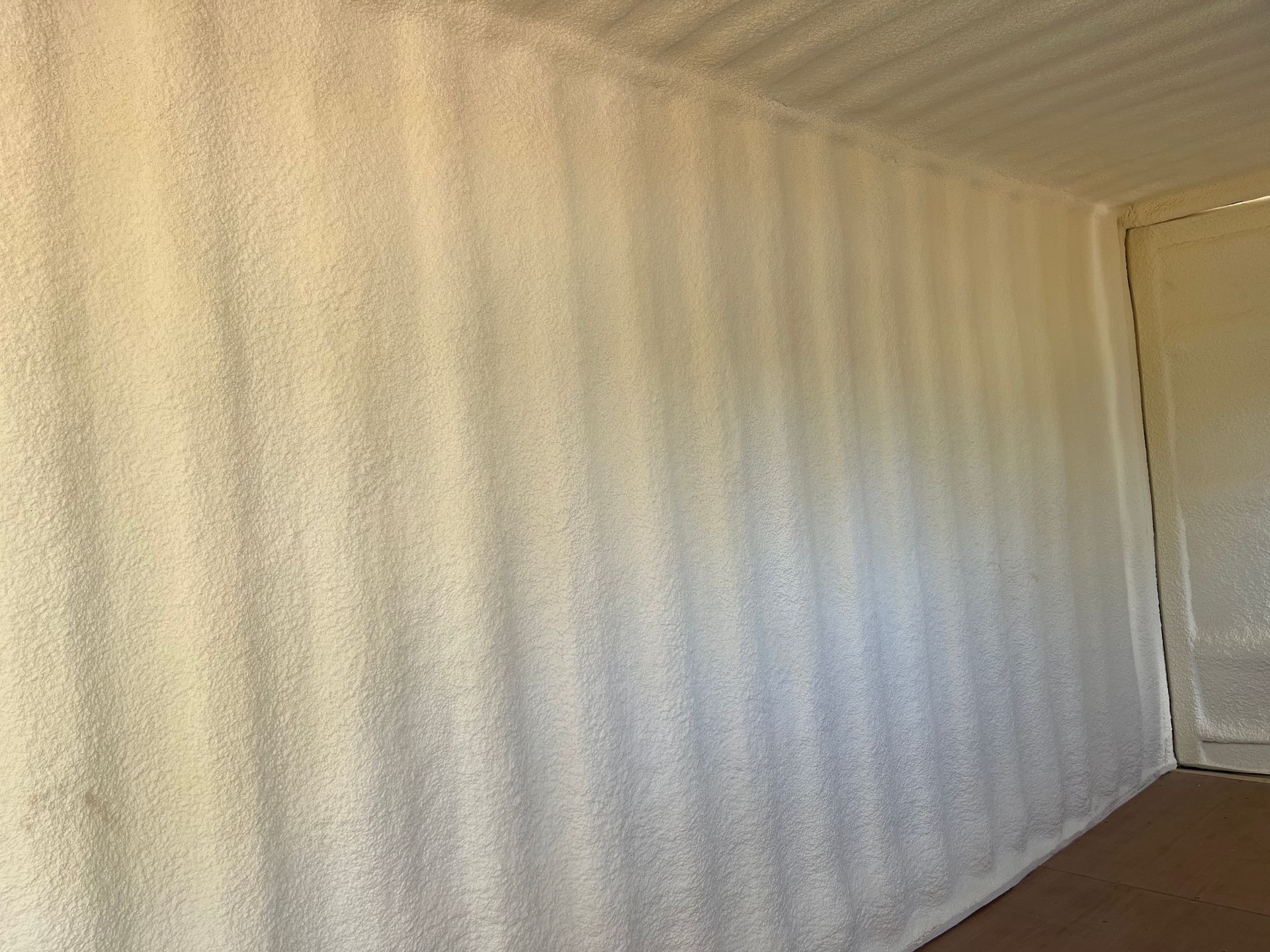 A room with a wall covered in white spray foam.