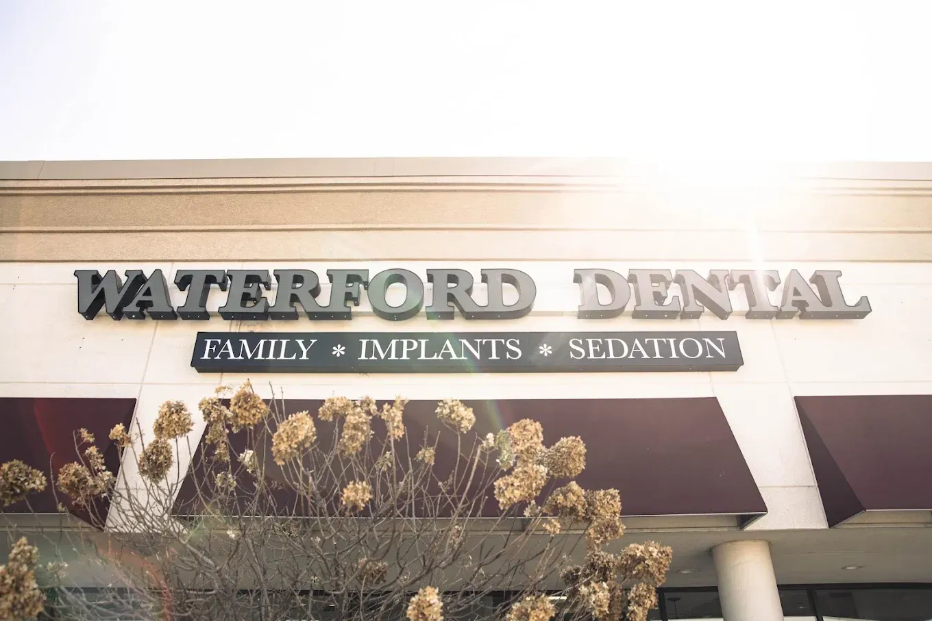 Waterford Dental building exterior with sign, offers family, implants, & sedation.