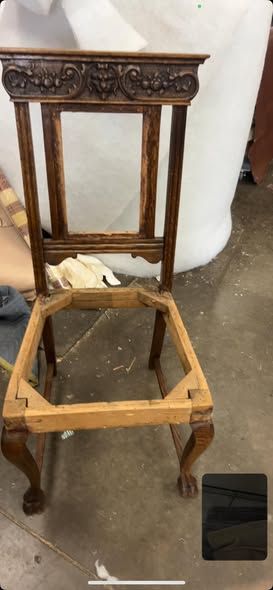 Wooden chair frame with ornate back detail, legs with claw feet, and open seat.